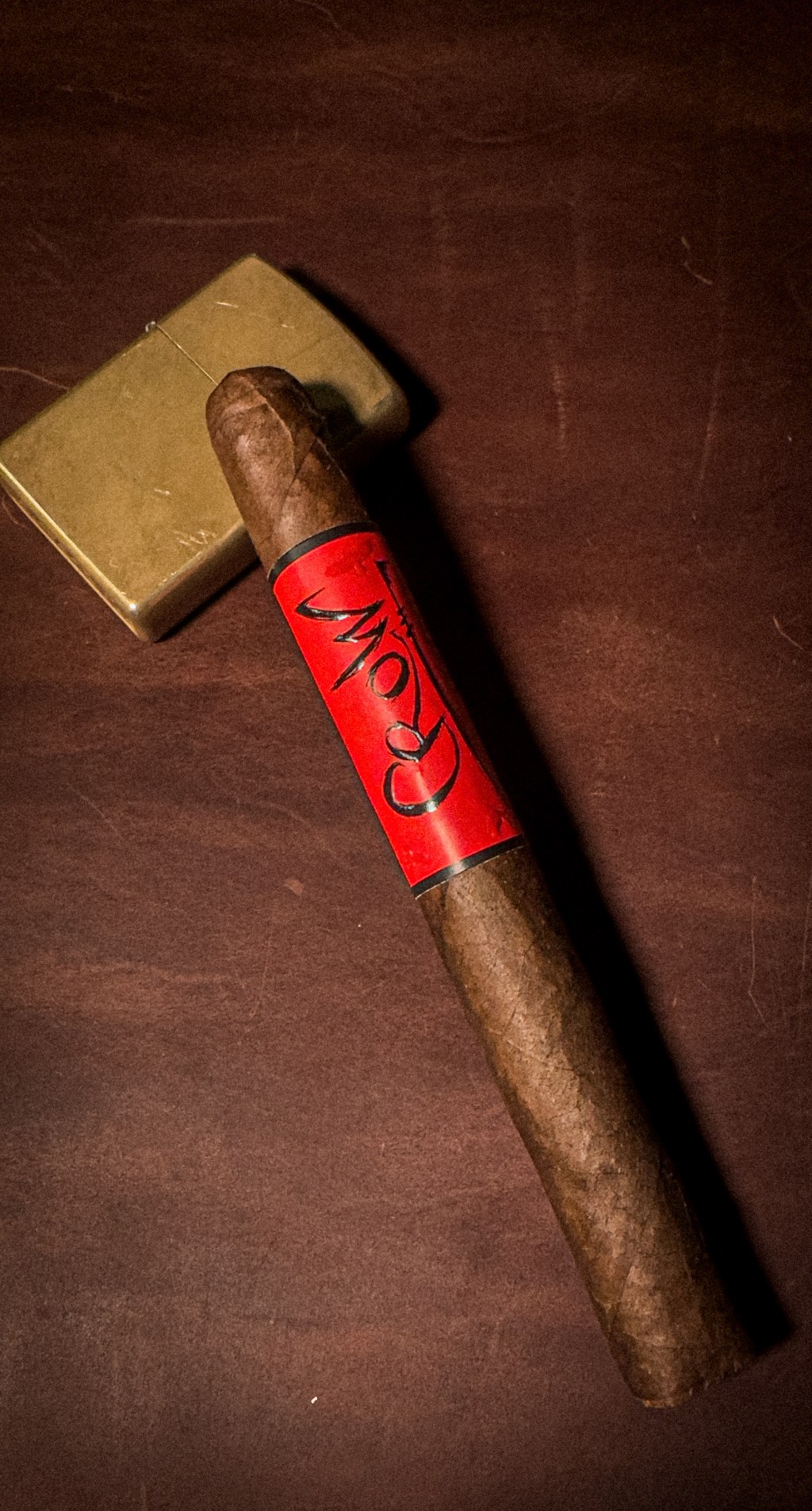 Blackbird Crow Corona cigar with red band on dark vintage tabletop